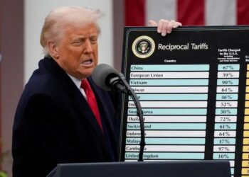 Donald Trump segura um quadro que exibe o que chama de tarifas desproporcionais cobradas por parceiros comerciais dos EUA (Foto: Kent Nishimura/Bloomberg)