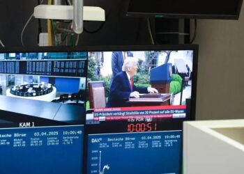 Monitor exibe uma transmissão de notícias com o ex-presidente dos EUA, Donald Trump, que anunciou tarifas comerciais ao lado da curva do índice DAX, na Bolsa de Valores de Frankfurt, na Alemanha, na quinta-feira, 3 de abril de 2025.
