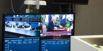Monitor exibe uma transmissão de notícias com o ex-presidente dos EUA, Donald Trump, que anunciou tarifas comerciais ao lado da curva do índice DAX, na Bolsa de Valores de Frankfurt, na Alemanha, na quinta-feira, 3 de abril de 2025.