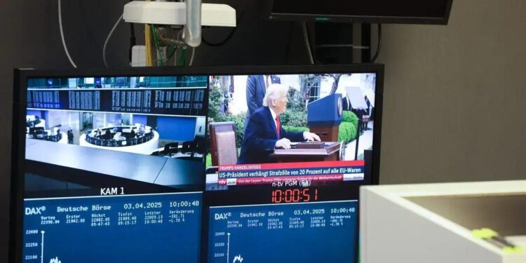 Monitor exibe uma transmissão de notícias com o ex-presidente dos EUA, Donald Trump, que anunciou tarifas comerciais ao lado da curva do índice DAX, na Bolsa de Valores de Frankfurt, na Alemanha, na quinta-feira, 3 de abril de 2025.